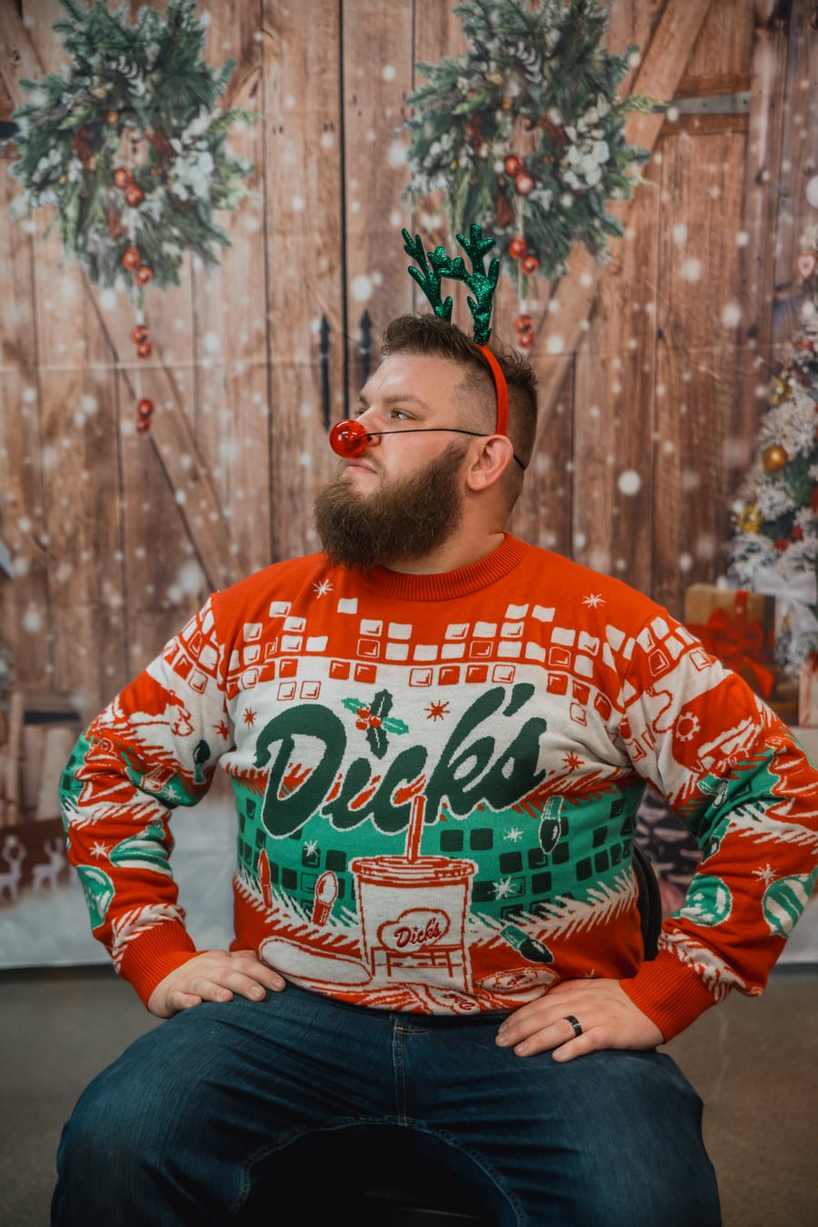 Brandon wearing a holiday sweater and reindeer antlers